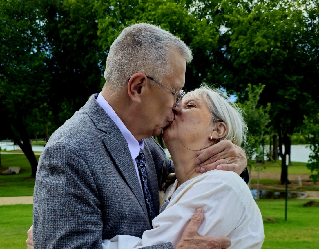 Kristin Milan and her husband sharing a kiss on their wedding day